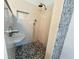 Close up of updated shower featuring unique pebble floor and tile walls at 13809 18Th E Pl, Bradenton, FL 34212