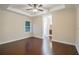 Spacious bedroom with hardwood floors, a ceiling fan, tray ceiling, and view to ensuite bathroom at 1420 E Frierson Ave, Tampa, FL 33603