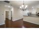 Open-concept dining area with modern chandelier and a view into the kitchen with stainless appliances at 1420 E Frierson Ave, Tampa, FL 33603