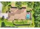 Overhead view of a home with a private screened pool surrounded by green lawns and mature trees at 15208 21St E Ave, Bradenton, FL 34212