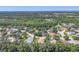 An aerial view of a neighborhood featuring homes surrounded by trees, ponds, and a lush landscape at 15208 21St E Ave, Bradenton, FL 34212