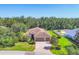 An aerial view of a landscaped single-story home featuring a three-car garage and brick paver driveway at 15208 21St E Ave, Bradenton, FL 34212