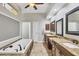 Luxurious bathroom featuring a soaking tub, double vanities with granite countertops, and tiled flooring at 15208 21St E Ave, Bradenton, FL 34212