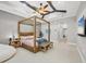 Bright bedroom featuring a four-poster bed, modern ceiling fan, and open doorway leading to other rooms at 15208 21St E Ave, Bradenton, FL 34212