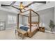 Spacious bedroom with a four-poster bed, ceiling fan, and ample natural light from the large window at 15208 21St E Ave, Bradenton, FL 34212