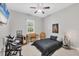 Bedroom with modern ceiling fan, musical instruments, and neutral tile flooring at 15208 21St E Ave, Bradenton, FL 34212