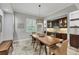 Elegant dining room with a large wooden table, modern lighting, and a built-in wine cabinet and bar area at 15208 21St E Ave, Bradenton, FL 34212