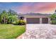 Charming single-story home featuring a three-car garage, manicured landscaping and a brick paver driveway at 15208 21St E Ave, Bradenton, FL 34212