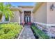 Elegant entryway features a brick pathway, lush landscaping, stone accents, and double glass front doors at 15208 21St E Ave, Bradenton, FL 34212