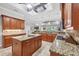 Open-concept kitchen with granite countertops, stainless steel appliances, and wood cabinetry with breakfast bar seating at 15208 21St E Ave, Bradenton, FL 34212