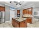 Kitchen island with granite countertop, stainless steel appliances, and natural wood cabinets with coffered ceiling at 15208 21St E Ave, Bradenton, FL 34212