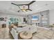 Spacious living room with large windows, a ceiling fan, and built-in shelving for storage at 15208 21St E Ave, Bradenton, FL 34212