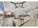 Open-concept living room with a large sectional sofa, breakfast bar with seating, and a coffered ceiling with a fan at 15208 21St E Ave, Bradenton, FL 34212