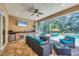 Screened outdoor space featuring a full kitchen, dining, and seating area near a pool with an attached spa at 15208 21St E Ave, Bradenton, FL 34212