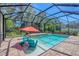 Relaxing screened pool area with in-pool seating and a waterfall feature, perfect for enjoying the outdoors at 15208 21St E Ave, Bradenton, FL 34212