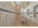 Modern walk-in shower featuring tiled walls, built-in shelving, and multiple shower heads for a luxurious experience at 15208 21St E Ave, Bradenton, FL 34212