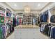 Expansive walk-in closet with custom shelving, hanging racks, and a granite island for storage and organization at 15208 21St E Ave, Bradenton, FL 34212