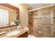 Bathroom with granite countertop, decorative mirror, and seamless glass shower enclosure at 1608 Stickney Point Rd # 304, Sarasota, FL 34231