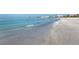 A wide shot of the beautiful white sand beach with waves coming ashore on a tranquil sunny day at 1608 Stickney Point Rd # 304, Sarasota, FL 34231