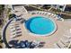 Aerial view of a sparkling pool with lounge chairs and tables at 1608 Stickney Point Rd # 304, Sarasota, FL 34231