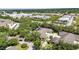 Aerial view of a well-manicured community surrounded by lush greenery, businesses, and roadways at 1651 Red Oak Ln, Port Charlotte, FL 33948