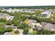 Aerial view of a well-manicured community surrounded by lush greenery, businesses, and roadways at 1651 Red Oak Ln, Port Charlotte, FL 33948