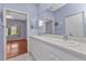 A full bathroom features a double sink vanity, mirrored medicine cabinet, and view to the primary bedroom at 1651 Red Oak Ln, Port Charlotte, FL 33948
