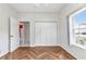 A bedroom with parquet flooring, closet with bifold doors, and doorway provides ample space at 1651 Red Oak Ln, Port Charlotte, FL 33948