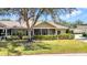 Charming home featuring a screened-in porch, mature tree, and meticulously maintained lawn at 1651 Red Oak Ln, Port Charlotte, FL 33948