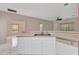 Kitchen features stainless steel sink, white cabinets, and adjacent living space at 1651 Red Oak Ln, Port Charlotte, FL 33948