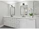 Bathroom featuring double sinks, white cabinetry, sleek fixtures, and bright lighting at 180 Lookout Point Dr, Osprey, FL 34229