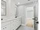 Bathroom featuring double sinks, white cabinetry, sleek fixtures, and bright lighting at 180 Lookout Point Dr, Osprey, FL 34229