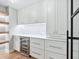 Butler's pantry features floating shelves, custom cabinets and a wine fridge at 180 Lookout Point Dr, Osprey, FL 34229