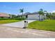 Exterior view of the home featuring a manicured lawn, driveway, and clean architectural lines at 180 Lookout Point Dr, Osprey, FL 34229