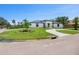 Beautiful home exterior with a curved driveway, lush lawn, and well-maintained landscaping at 180 Lookout Point Dr, Osprey, FL 34229