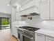 Close-up of a kitchen with marble backsplash, stainless steel oven, and outdoor pool view at 180 Lookout Point Dr, Osprey, FL 34229