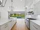 Bright kitchen with white cabinets and hardwood floors with a view of the pool at 180 Lookout Point Dr, Osprey, FL 34229