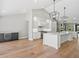 Bright kitchen with white cabinets, stainless steel appliances, large island, and modern lighting at 180 Lookout Point Dr, Osprey, FL 34229