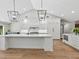 Stylish kitchen features white cabinetry, marble countertops, designer lighting, and stainless steel appliances at 180 Lookout Point Dr, Osprey, FL 34229