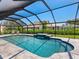 Screened in pool offers blue water, an inset spa, and ample space for lounging at 180 Lookout Point Dr, Osprey, FL 34229