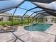 Screened in pool area with sun loungers, tile flooring, and outdoor kitchen at 180 Lookout Point Dr, Osprey, FL 34229