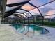 Screened in pool at twilight with attached spa and outdoor seating at 180 Lookout Point Dr, Osprey, FL 34229