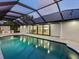 The pool is surrounded by a screened enclosure, offering views of the kitchen and access to the home at 180 Lookout Point Dr, Osprey, FL 34229