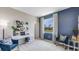 Stylishly decorated den with white desk, blue accent wall, and natural light from a large window at 18109 Cropside Trl, Lakewood Ranch, FL 34211