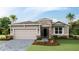 Charming single story home featuring stone accents, a two-car garage, and lush landscaping at 18225 Beach Ranch Ter, Lakewood Ranch, FL 34211