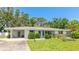 A charming single-story home featuring a carport and a beautifully landscaped front yard at 2110 Craft Ln, Sarasota, FL 34239