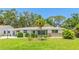 Well-maintained single-story home with a lush green lawn and mature trees at 2110 Craft Ln, Sarasota, FL 34239