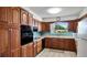 Traditional kitchen featuring wood cabinetry, neutral countertops, and blue tile backsplash at 2110 Craft Ln, Sarasota, FL 34239