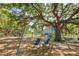 Community swing set and playground under the shade of a large tree at 2110 Craft Ln, Sarasota, FL 34239