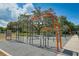 A workout area with orange and grey bars, surrounded by lush greenery and a cloudy sky, perfect for exercise at 2110 Craft Ln, Sarasota, FL 34239